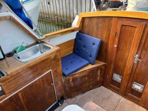 a small boat with a sink and a blue seat at Romantisk båd nær Kbh in Copenhagen