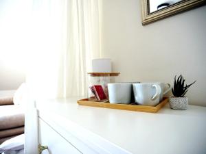 a tray with two mugs and a plant on a table at Slavia penzion in Mikulov