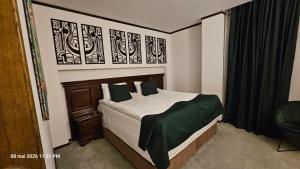 a bedroom with a bed with a green and white blanket at Alpin Aparthotel Ap 508 Poiana Brasov- acces la piscină gratuit in Poiana Brasov +82 photos
