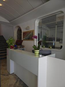a lobby with a white counter with flowers on it at Hotel Ornella in Bellaria-Igea Marina +24 photos
