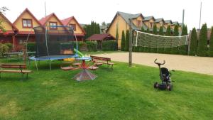 a playground with a trampoline and a scooter in the grass at Dw Perła Sarbinowo in Sarbinowo