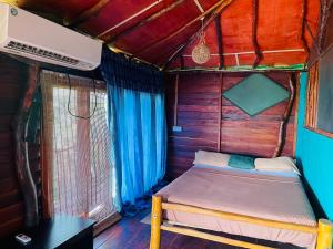 a small bed in a room in a house at Eco Tree House Yala in Tissamaharama