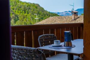 a table with a coffee maker and chairs on a balcony at Apartments Bernard in Aldino