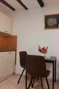 a kitchen with a table and two chairs in a room at APARTMAN B in Split