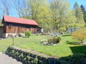 a house with a yard with chairs and a barn at Chalupa Na Křemence in Třinec