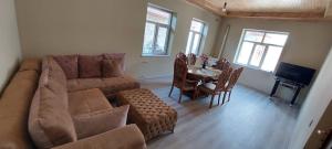 a living room with a large couch and a table at Comfort Hills in İsmayıllı