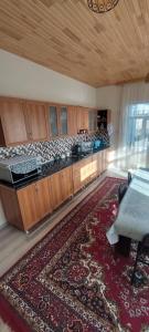 a large kitchen with wooden cabinets and a rug at Comfort Hills in İsmayıllı