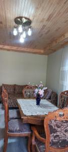 a dining room table with a vase of flowers on it at Comfort Hills in İsmayıllı +17 photos