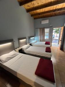 two beds in a hotel room with a red rug at Amambay Apart &Suites in Eldorado +22 photos
