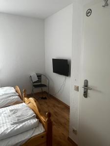 a bedroom with a bed and a tv and a chair at Ferienwohnung Fatlume No 6 in Bad Honnef am Rhein
