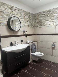 a bathroom with a sink and a toilet and a mirror at Ferienwohnung Fatlume No 6 in Bad Honnef am Rhein