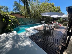 a deck with a table and chairs next to a pool at Amambay Apart &Suites in Eldorado