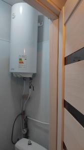 a bathroom with a toilet and a water tank at Котэдж Посуточно in Zhovti Vody