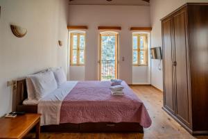 a bedroom with a bed and a table and windows at Panoramic View House in Symi