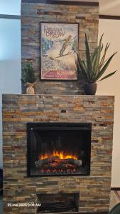 a fireplace with a stone wall with a fire place at Alpin Aparthotel Ap 508 Poiana Brasov- acces la piscină gratuit in Poiana Brasov