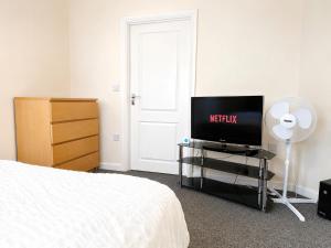 a bedroom with a bed and a tv and a dresser at Private Ensuite room in Wolverhampton city centre in Wolverhampton