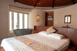 a bedroom with a bed and a bath tub at QUEEN VILLA - Hoa Tiên paradise in Ðông Hội +38 photos