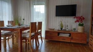 a dining room table with chairs and a tv on a wall at Hus 25 Wandlitz Zerpenschleuse in Wandlitz