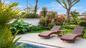two chairs and a table next to a swimming pool at QUEEN VILLA - Hoa Tiên paradise in Ðông Hội