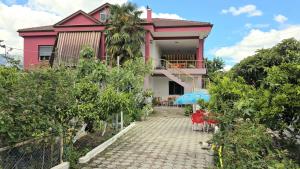 a pink house with a balcony and a patio at Guest house Sherifi in Berat