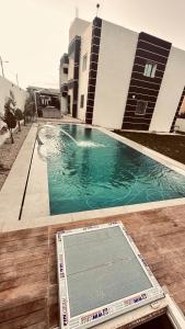 a swimming pool in front of a building at Appartements de rêve in Hennchir Ksar Rhaleb