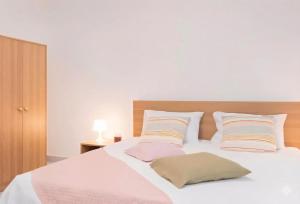 a bedroom with a white bed with pillows at The Pearl Nest Spacious 2BHK in Madinatna Better Than a Hotel, Halff the Price in Doha