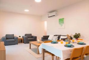 a living room with a table and chairs at The Pearl Nest Spacious 2BHK in Madinatna Better Than a Hotel, Halff the Price in Doha
