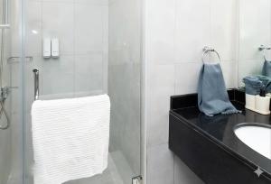 a bathroom with a glass shower and a white towel at The Pearl Nest Spacious 2BHK in Madinatna Better Than a Hotel, Halff the Price in Doha