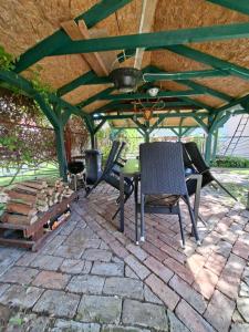 a patio with a table and chairs and a fireplace at Csalogány 19 Apartman in Mezőkövesd