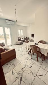 a living room with a table and a couch at Appartements de rêve in Hennchir Ksar Rhaleb