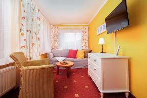 a living room with a couch and a tv at Muschelbank in Thiessow