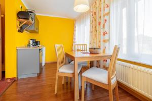 a dining room with yellow walls and a table and chairs at Muschelbank in Thiessow