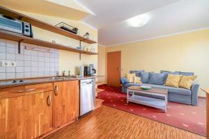 a kitchen and a living room with a blue couch at Leuchtfeuer in Thiessow