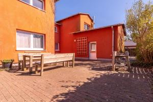 two wooden benches sitting in front of a building at Heimathafen in Thiessow +2 photos