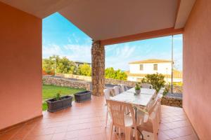 a dining room with a table and chairs on a patio at Tavolara Ichnos House in San Teodoro