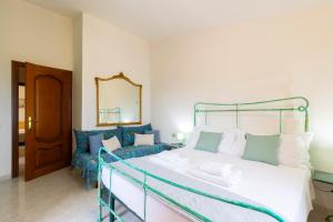 a bedroom with a bed and a couch and a mirror at Tavolara Ichnos House in San Teodoro