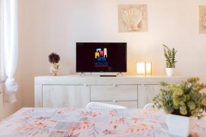 a living room with a tv and a table at Tavolara Ichnos House in San Teodoro