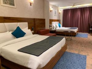 a hotel room with two beds and a table at Palmdale Hotel & Resort in Ambāla
