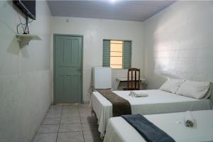 a room with two beds and a table in it at Porto Seguro Hotel - Porto Velho in Porto Velho