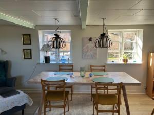 a dining room with a wooden table and chairs at Boots and Bikes B&B in Neksø
