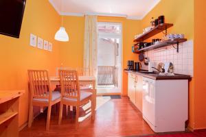 a kitchen with a table and a kitchen with yellow walls at Wellengang in Thiessow