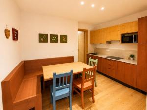 a kitchen with a wooden table and chairs at Rosso Betulle, Free Park and Ski room in Camporosso in Valcanale