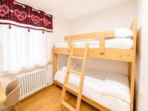a bedroom with two bunk beds and a desk at Rosso Betulle, Free Park and Ski room in Camporosso in Valcanale