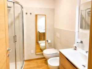 a bathroom with two toilets and a glass shower at Rosso Betulle, Free Park and Ski room in Camporosso in Valcanale +10 photos