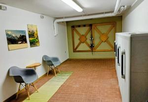 a room with two chairs and a door and a table at Rosso Betulle, Free Park and Ski room in Camporosso in Valcanale