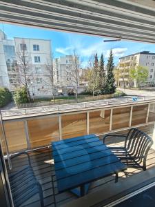 a blue bench and two chairs on a balcony at Kaupunkikoti omalla saunalla sekä lähellä juna-asemaa, 100M Wifi in Järvenpää +3 photos