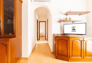 a living room with a tv on a wooden cabinet at Molara Ichnos House in San Teodoro