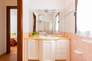 a bathroom with a sink and a mirror at Molara Ichnos House in San Teodoro +18 photos