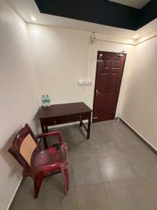 a room with a chair and a table and a door at Bliss Stay in Mūvattupula +14 photos