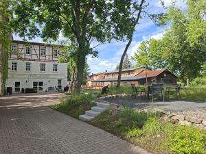 a park with tables and chairs and a building at Holiday Apartment Henry - Auszeit unter alten Balken in Arnstadt